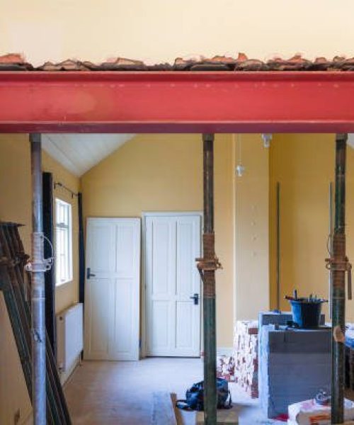 Building construction work in UK residential property with new wall opening supported by RSJ universal steel beam